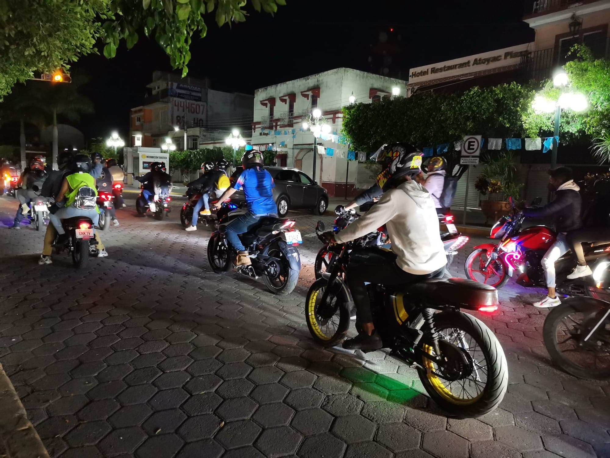 Grupo de motociclistas reunidos antes de una rodada nocturna